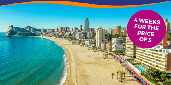 Coastal view of a sandy beach with a city skyline and a promotional banner for a holiday offer.