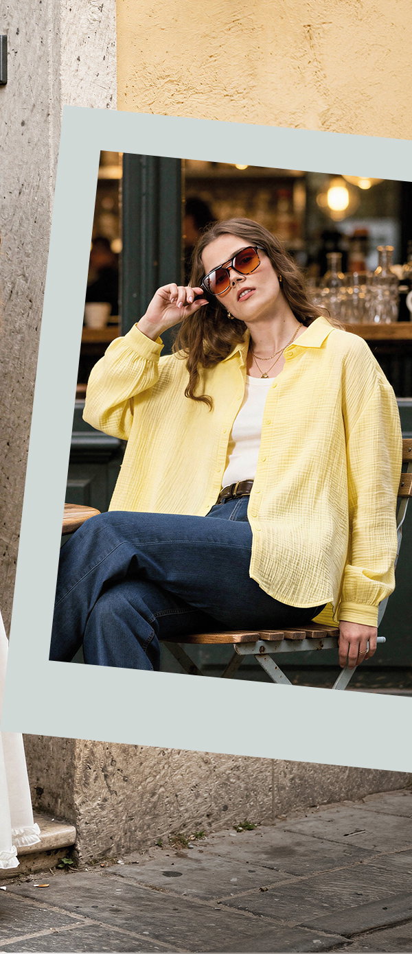 Frauenmodel trägt gelbes Hemd, weißes Top, blaue Jeans, sonnige Umgebung, Vorderansicht