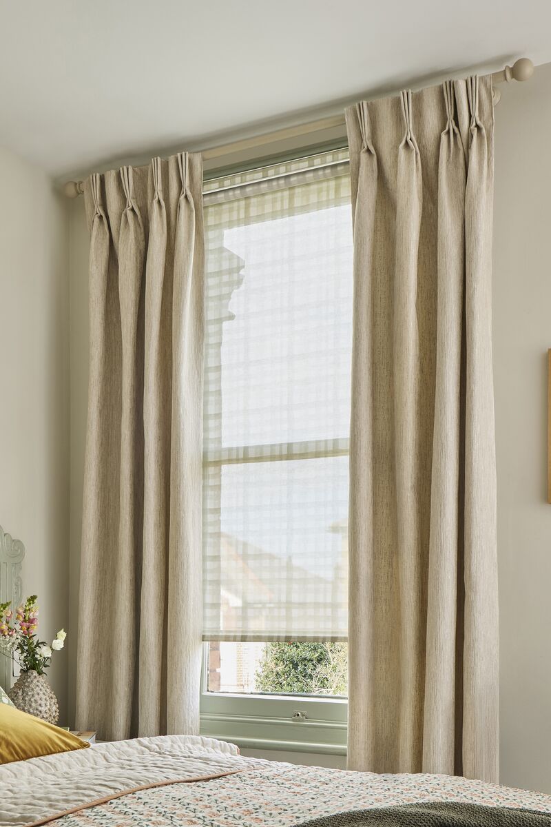  Bedroom window dressed with neutral floor-length curtains and a white sheer blind