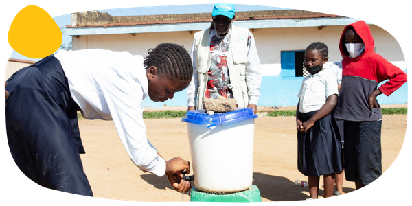 A young girl washing her hands. 