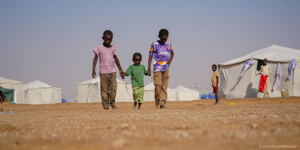 Children walking through a displaced persons camp.
