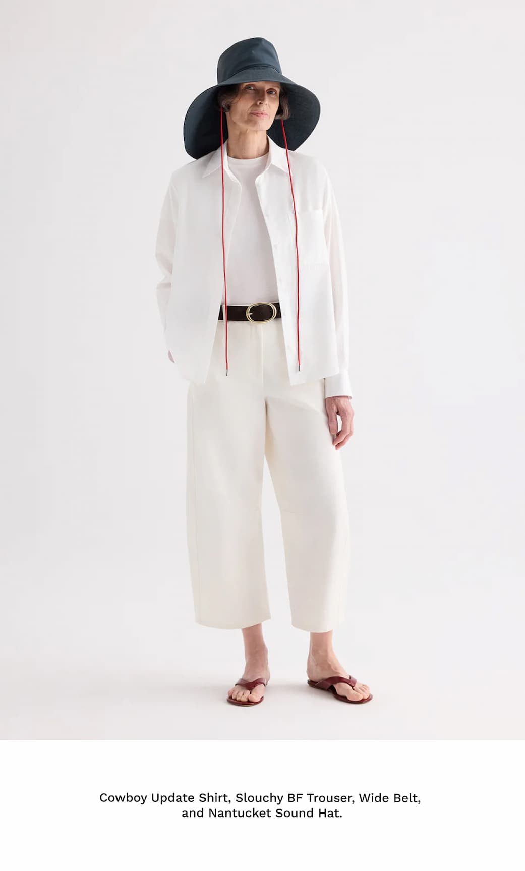 Image of a model in a white outfit and green hat followed by black text beneath.