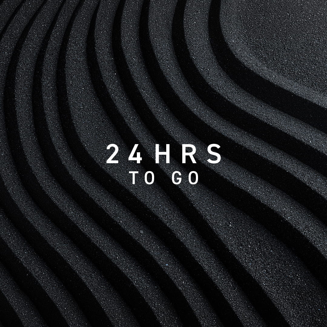 An Image of wavy black sand with the text 24 HRS TO GO