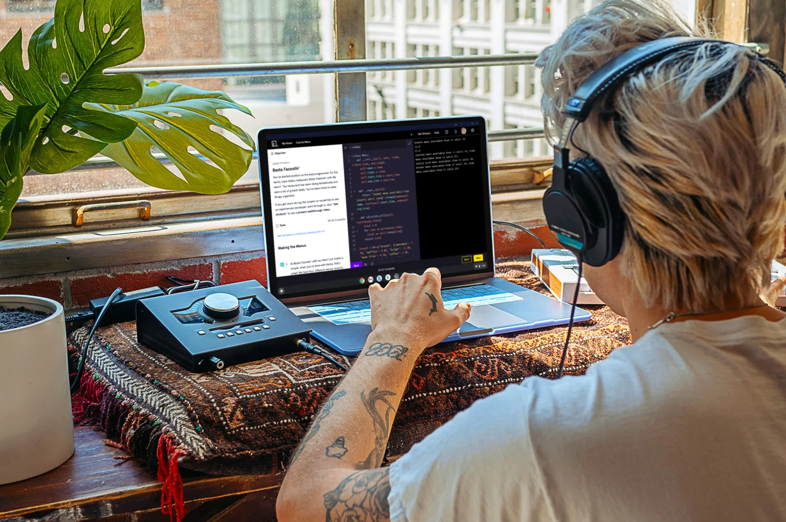 person sitting in a desk while coding with headphones on