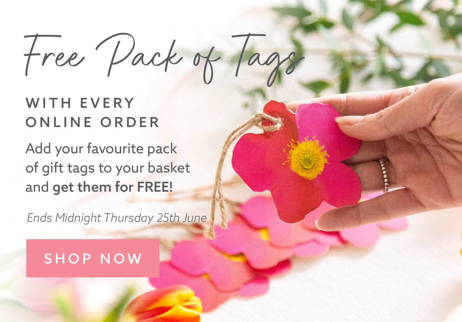 Hand holding a flower-shaped gift tag alongside matching gift tags and ribbon