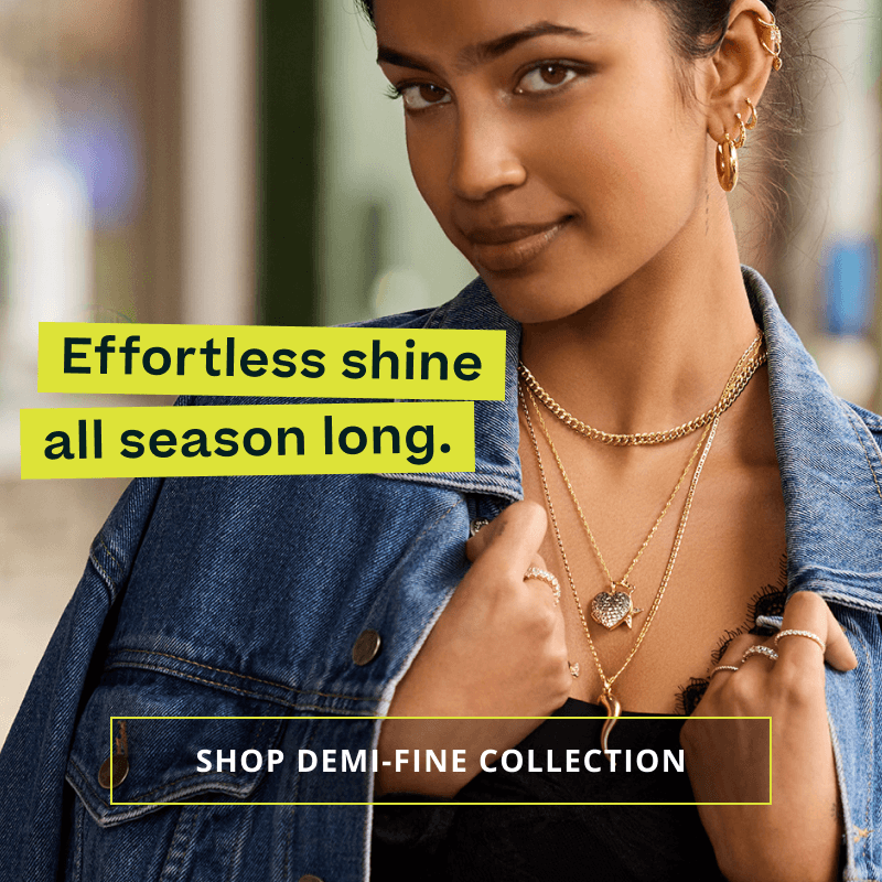 Model in mixed metal charm chains, rings & bracelets. Effortless shine. Click here to shop demi-fine collection