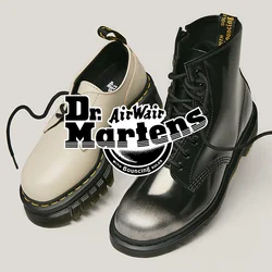 Ein beiger, tief ausgeschnittener Schuh und ein schwarzer, hoch geschnittener Stiefel mit Schnürsenkeln vor einem schlichten, hellen Hintergrund.