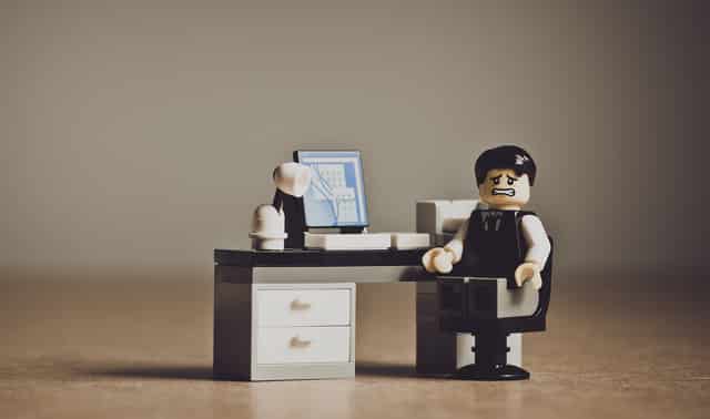 A Lego man working at an office built of Legos.