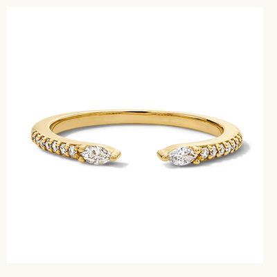 A gold ring with an open design and diamonds along the shank.