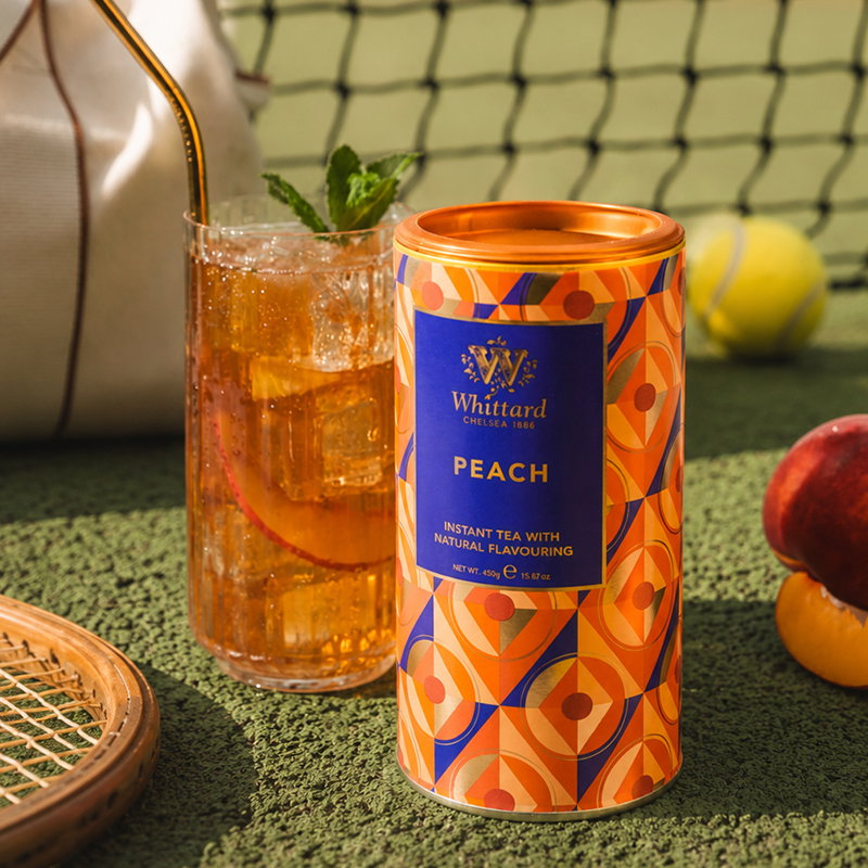 image of peach instant tea tub with made up drink and fruit around on tennis court