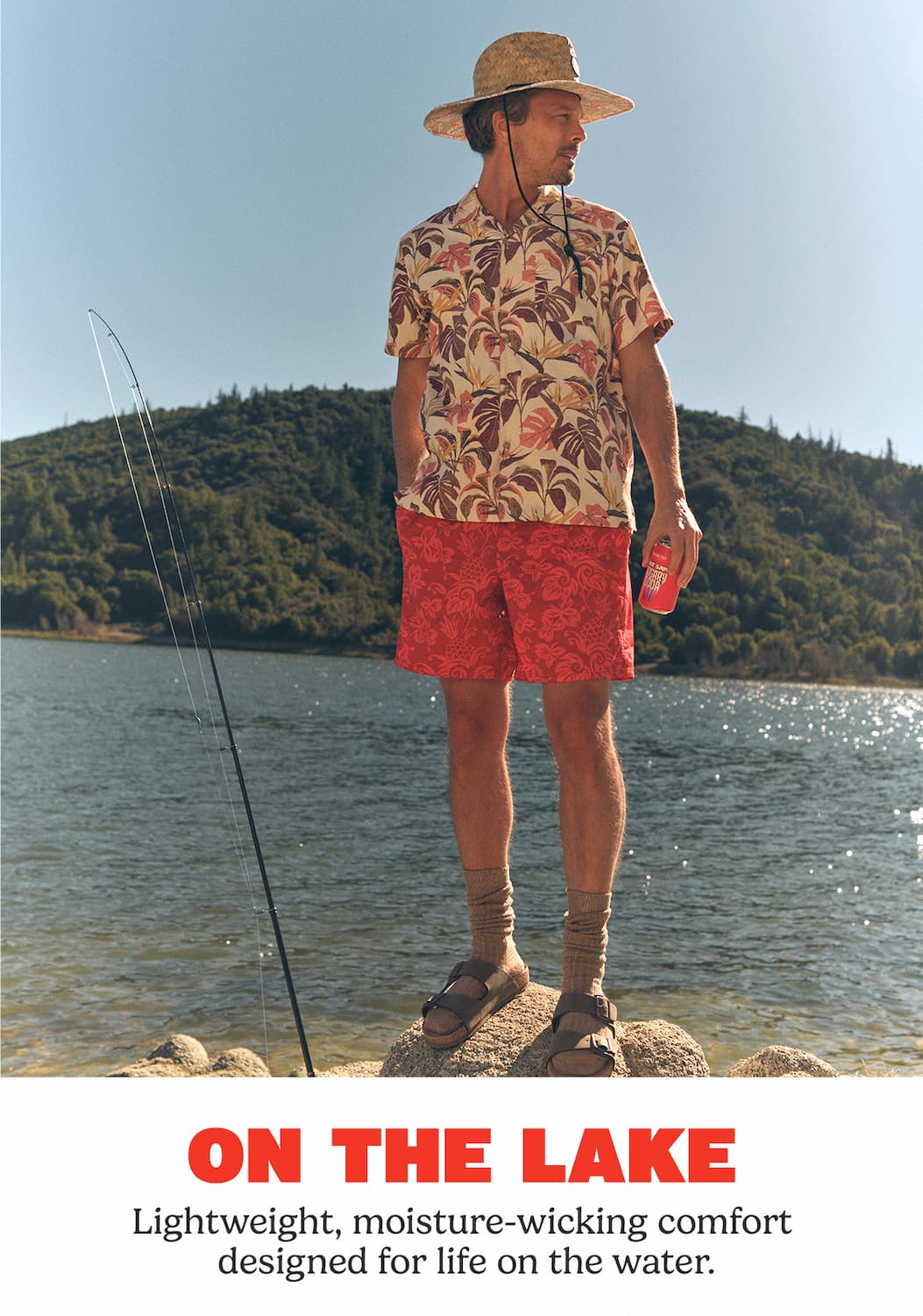 Man standing near a fishing pole on a lake.