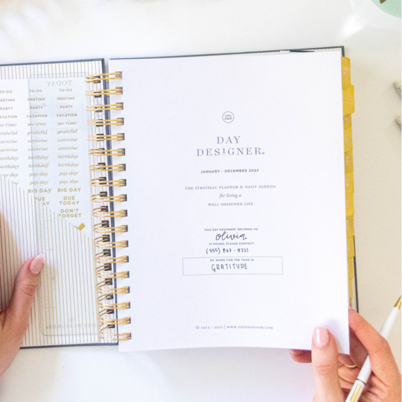open book day designer planner showing cover page with logo