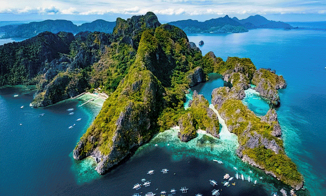 Lush green mountains surrounded by turquoise waters.