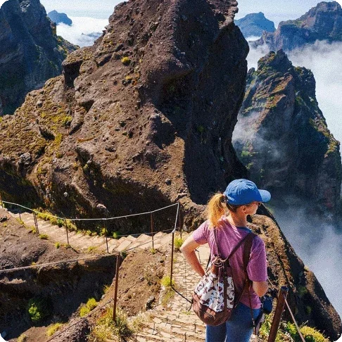 Image Description: A person standing on stairs overlooking mountains.
