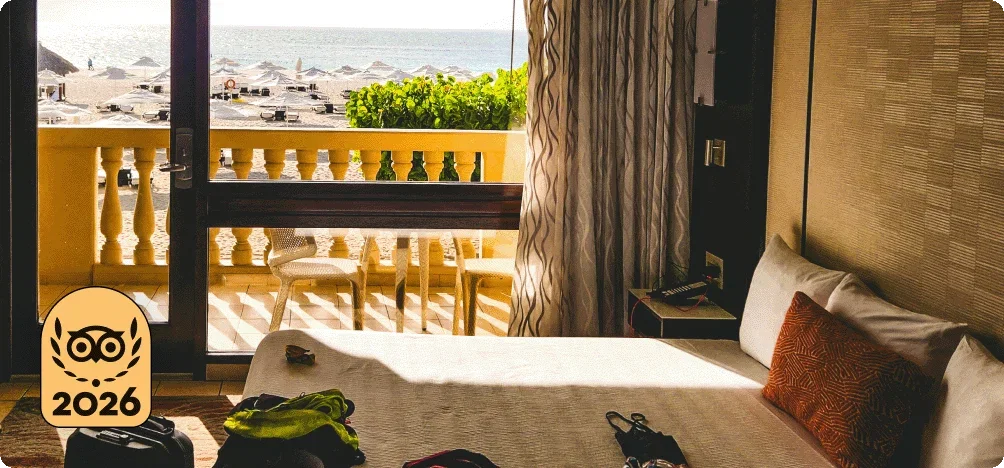 Image Description: A bed next to a balcony overlooking a city.