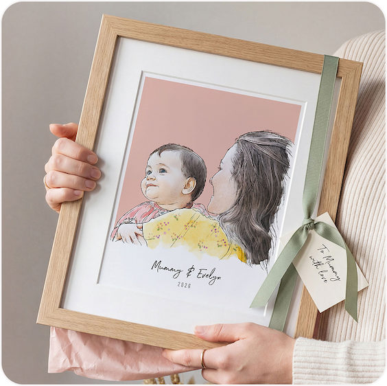 A framed watercolour illustration of a mother and child, held up against a warm peachy background with a gift tag attached