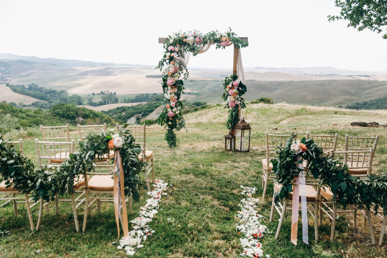 Wedding arch with blush floral arrangements and greenery