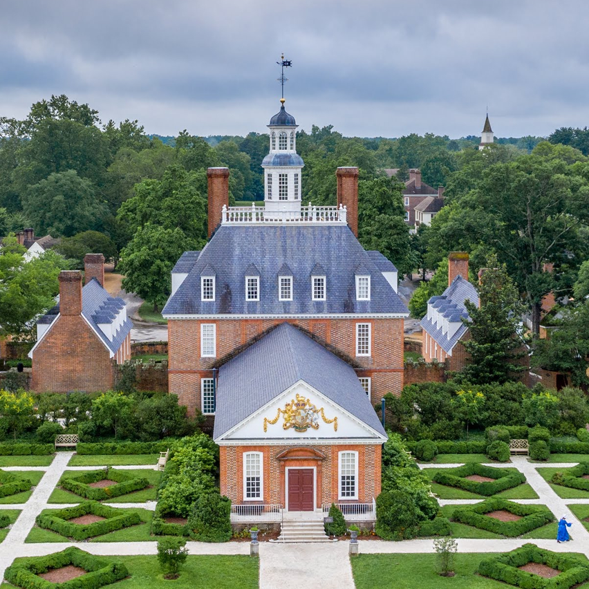 Aerial view of a red brick colonial mansion and formal garden