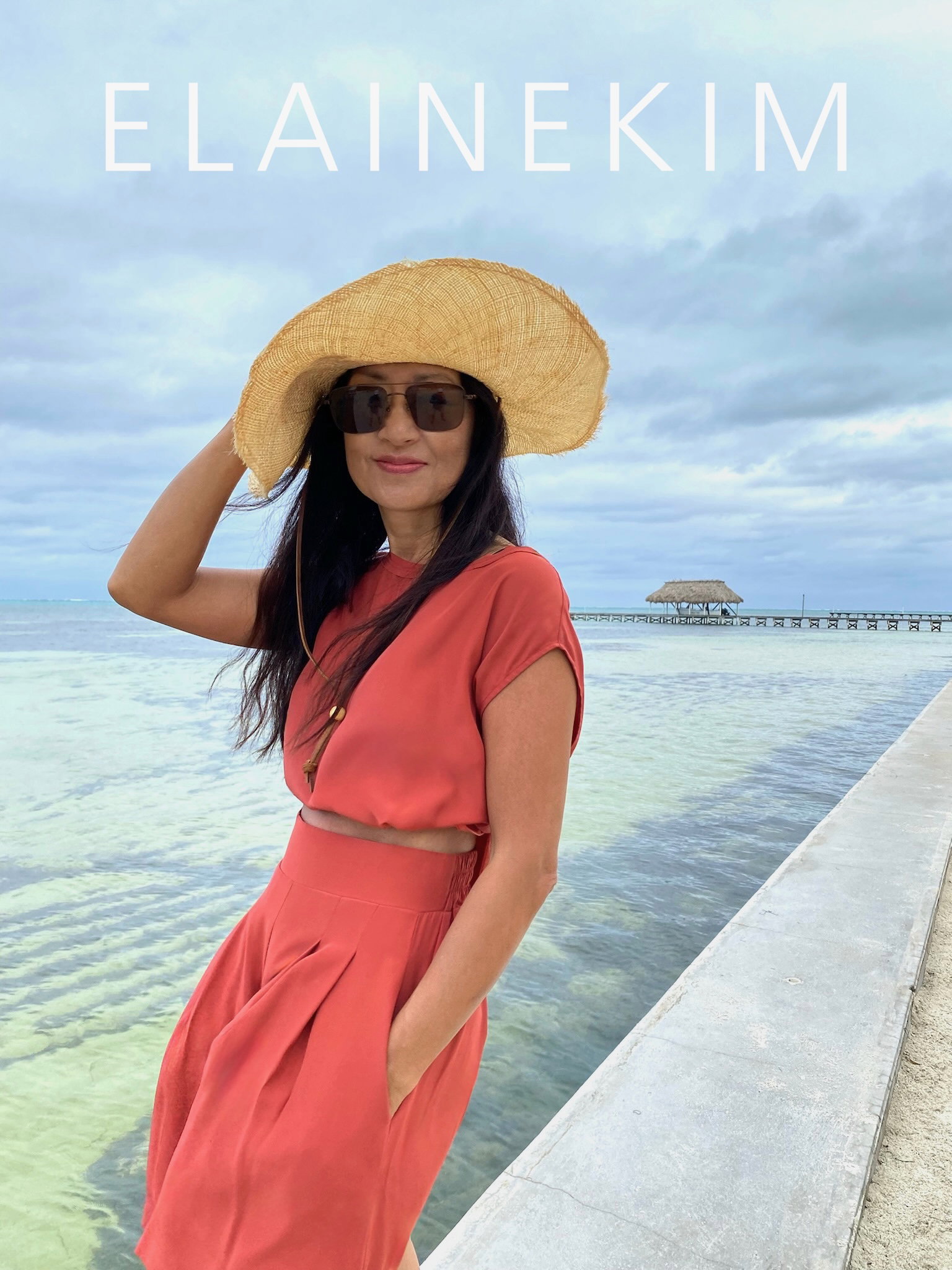 Elaine Kim wearing orange top and shorts in a tropical destination