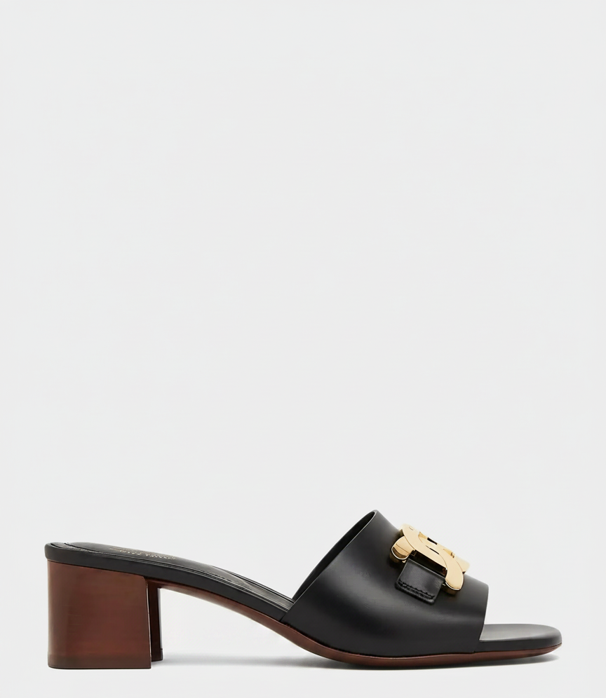 Black leather slide sandal with gold logo detail and block heel.