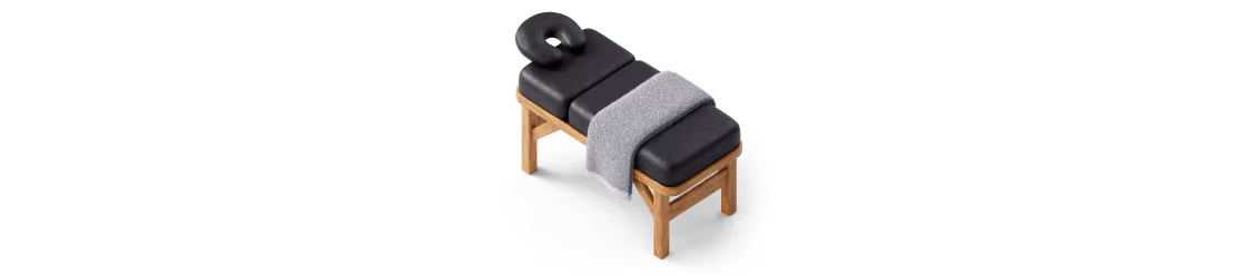 An illustration of a massage table with a towel draped over it.