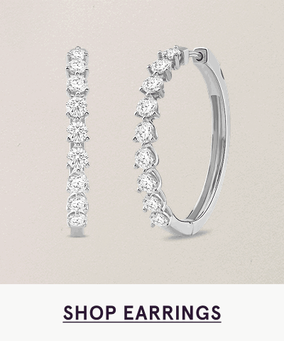 Medium-sized silver hoops with round diamonds along half of outer rim. Click here to shop earrings