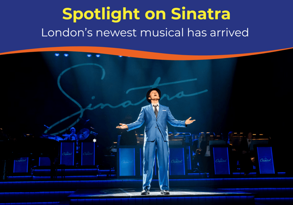 A performer in a blue suit sings passionately on stage, with a band in the background.