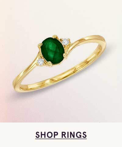 Gold ring with centered oval green gemstone. Click here to shop rings