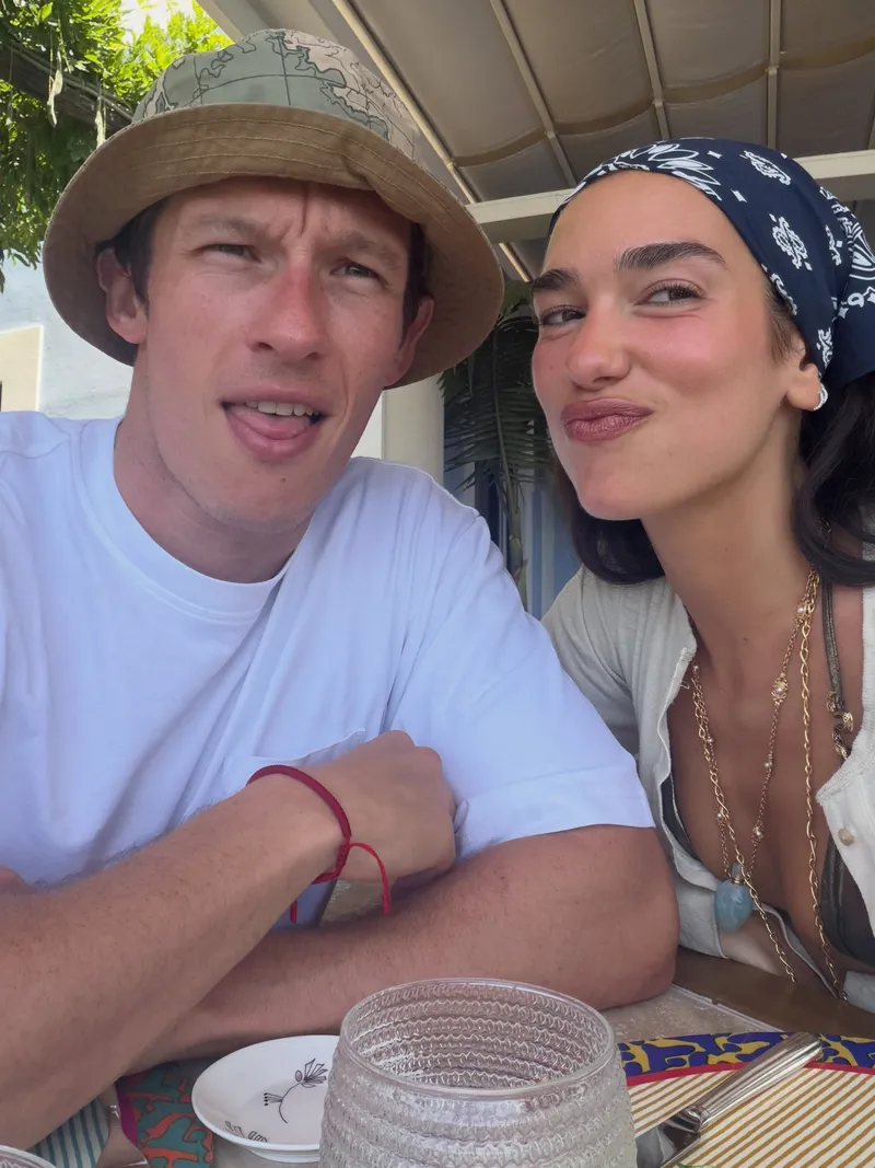 Image may contain: Callum Turner, Dua Lipa, Face, Head, Person, Photography, Portrait, Clothing, Hat, and Accessories