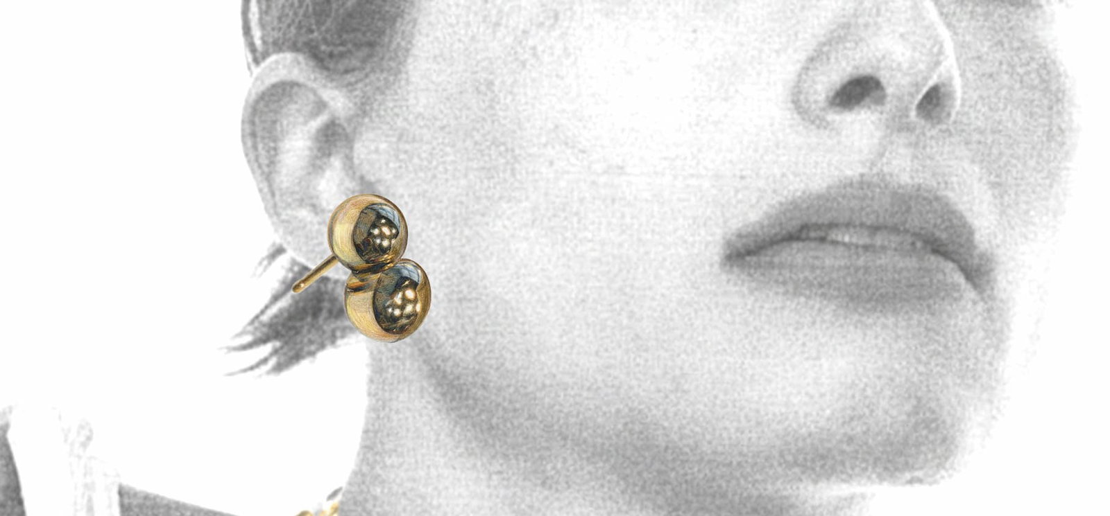 Black and white model close-up wearing Mejuri gold earrings.