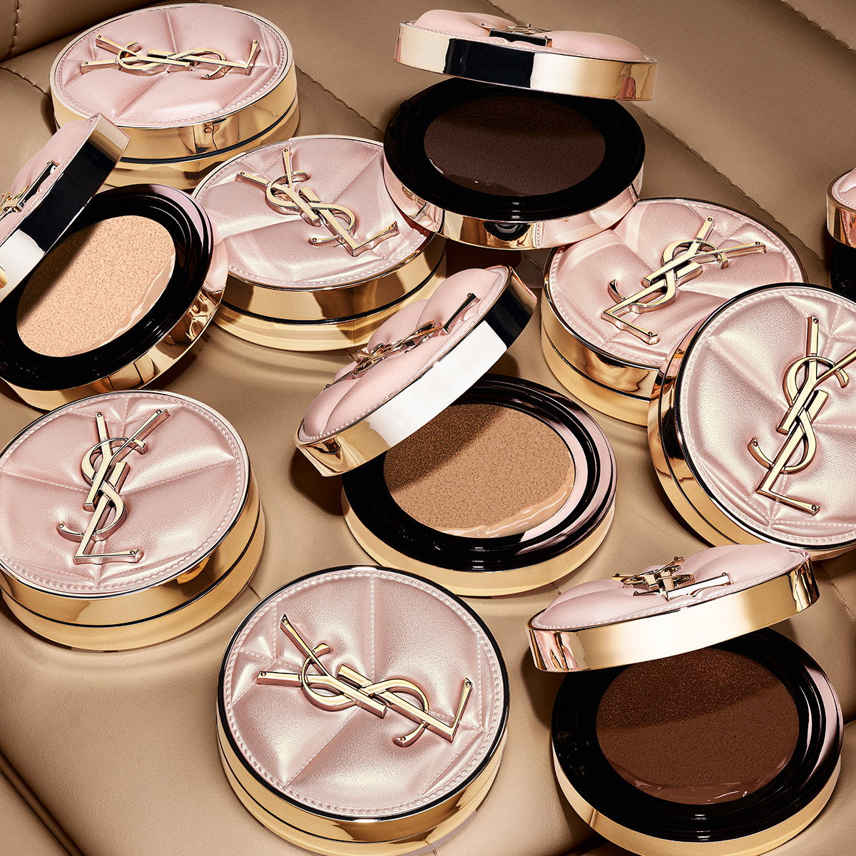 Multiple YSL cushion foundation compacts with quilted pink and gold cases displayed in various shades.