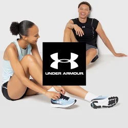 Zwei Personen in Sportbekleidung sitzen vor einem glatten, hellen Hintergrund. Die eine trägt ein hellblaues Tanktop, schwarze Shorts und blaue Laufschuhe. Die andere ist in einem schwarzen Muskelshirt, grauen Shorts und orangefarbenen Laufschuhen gekleidet.
