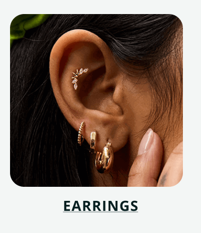 Curved climber cartilage & textured gold hoops & huggies on ear. Click here to shop earrings