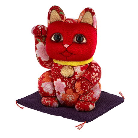 Lucky cat ornament in patterned red fabric, handcrafted using the traditional kimekomi technique. - Shop Now.