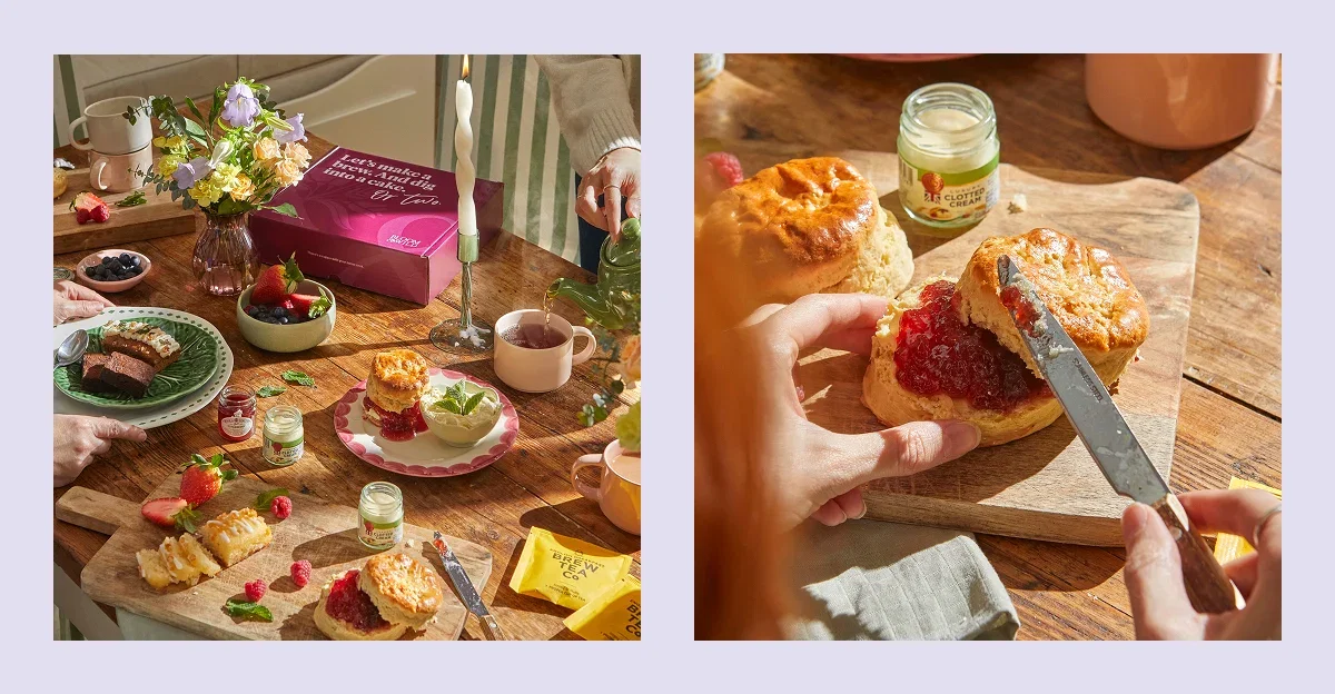 A sunny afternoon tea spread with a Bloom & Wild gift box. Features golden, flaky scones being spread with vibrant strawberry jam and clotted cream, lemon loaf slices, fresh berries, hot tea being poured, and a small pastel bouquet.