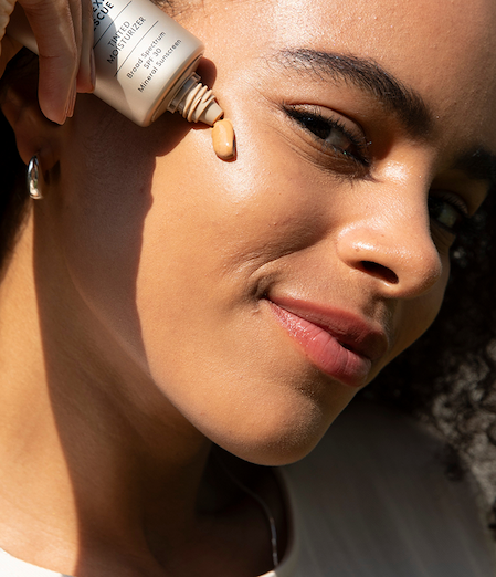 Model applying Tinted Moisturizer