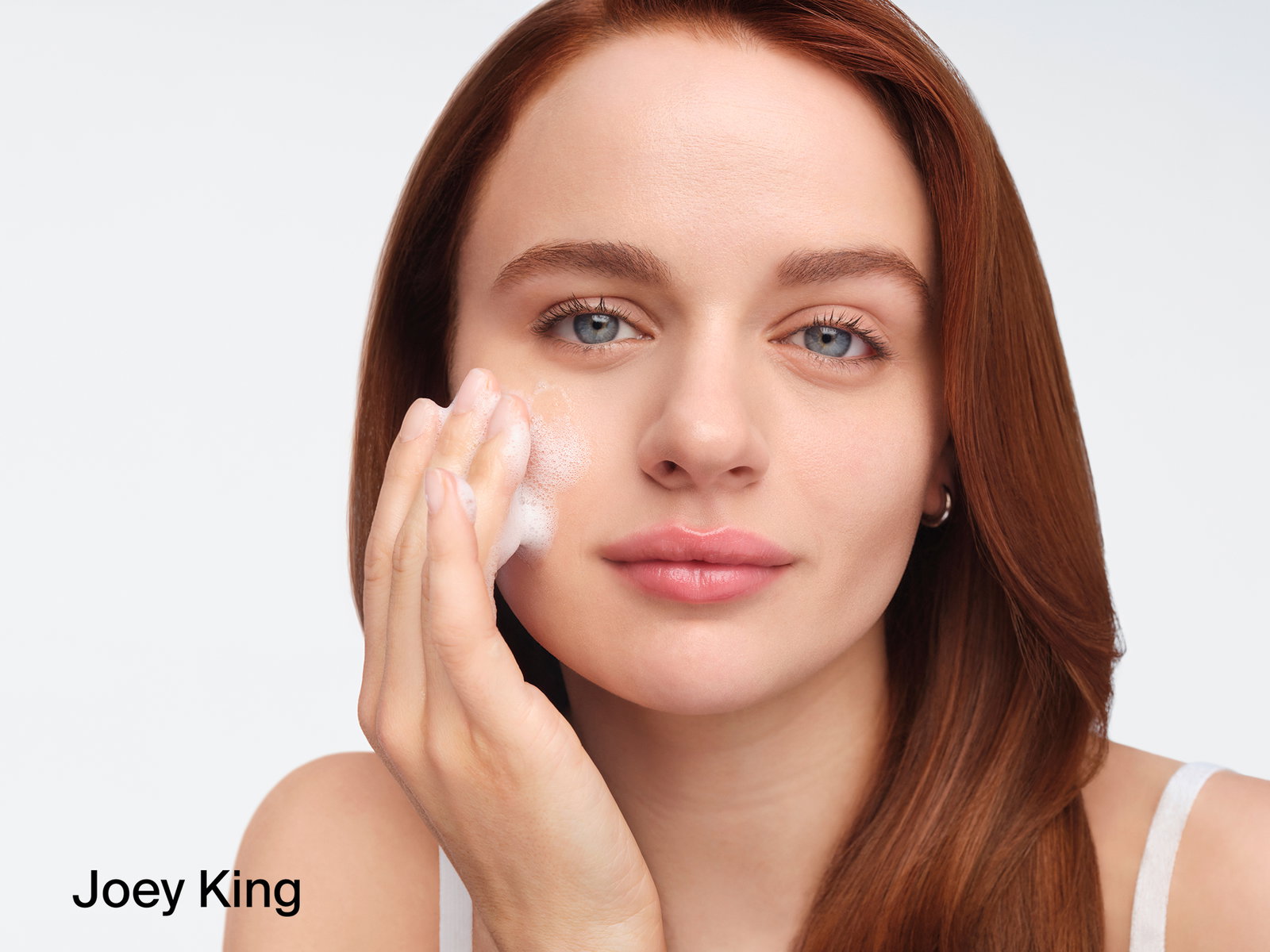 Joey King applying Neutrogena® Evenly Clear™ Acne Cleanser to face