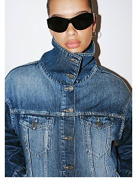 Model wearing denim jacket and black sunglasses