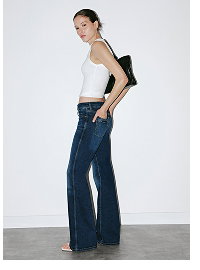 Woman wearing cream tank top and dark blue wide-leg jeans