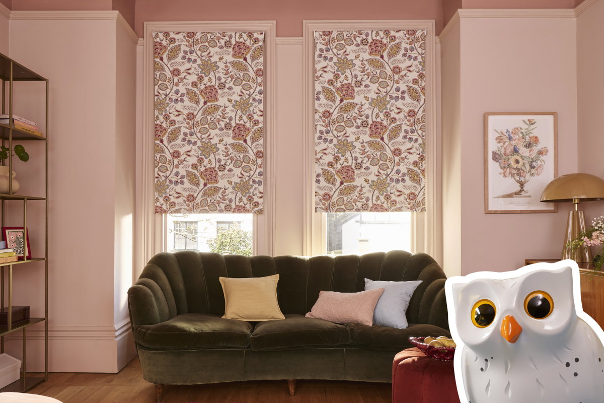 Two matching pink and white floral patterned roller blinds behind a dark v