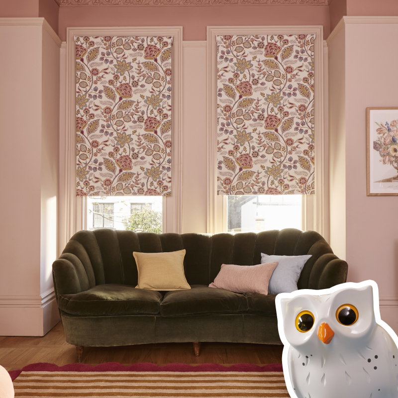 Two matching pink and white floral patterned roller blinds behind a dark v