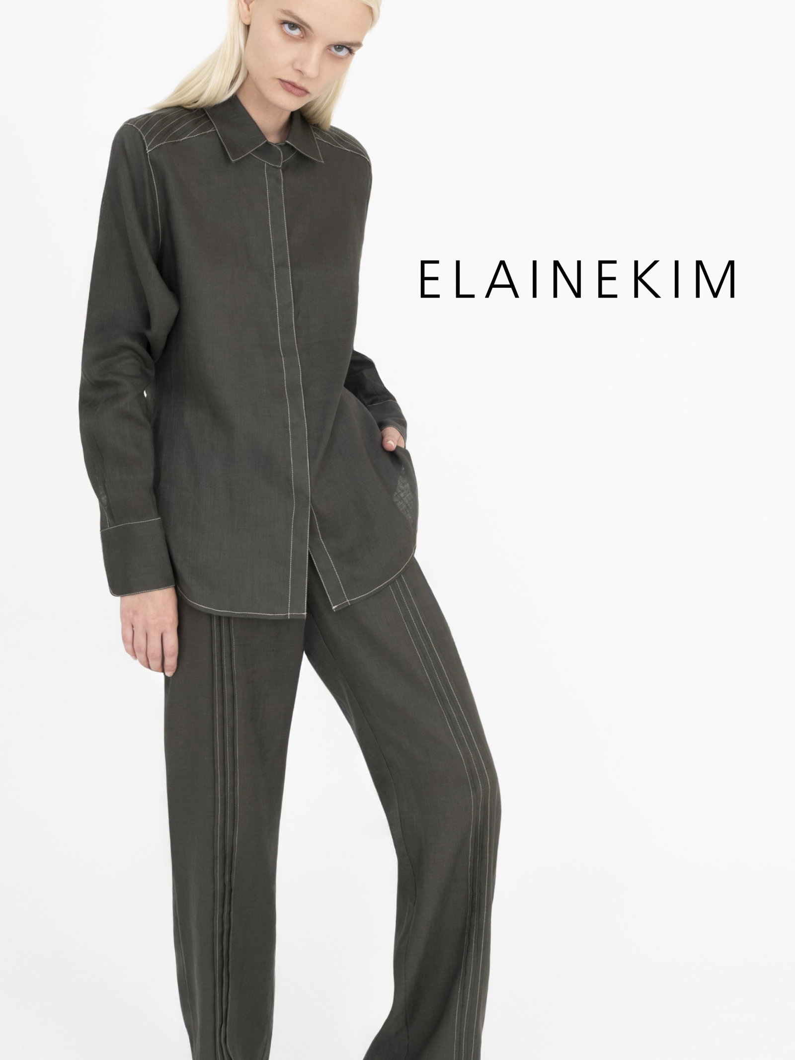 Woman wearing pine green shirt and pants on a white background