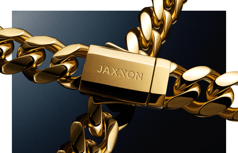Close up of a yellow gold tone Cuban link chain featuring a JAXXON clasp