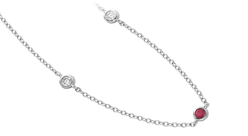 A silver chain with two diamond stones on the side and a ruby stone at the center. 
