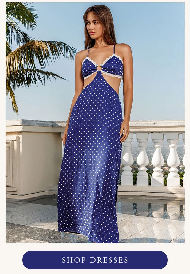 Model wearing navy maxi dress with polka dots. Shop dresses. 