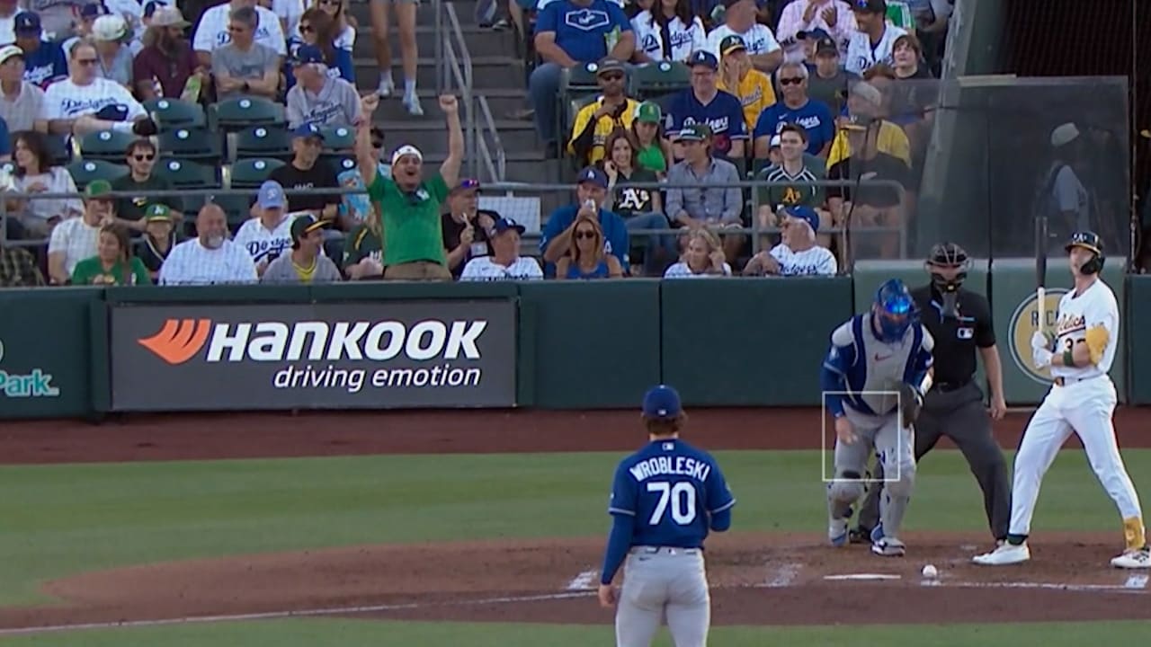 A fan in a green Mexico jersey celebrates a goal in the first row at the Dodgers-A's game in West Sacramento