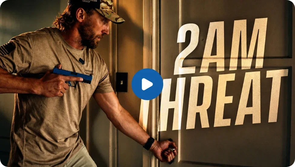 A man with a blue training pistol held high and tightly against his chest reaches out a hand to turn the knob on an interior residential door. The words 
