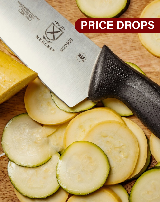 Mercer Culinary chef knife resting on a wooden cutting board surrounded by freshly sliced zucchini and yellow squash, with a Price Drops banner above.