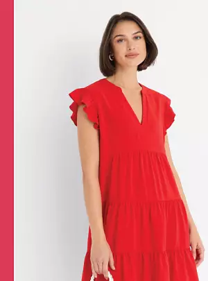 50% off dresses from Maison Tara, Robbie Bee, MSK and more. A woman in a red dress.