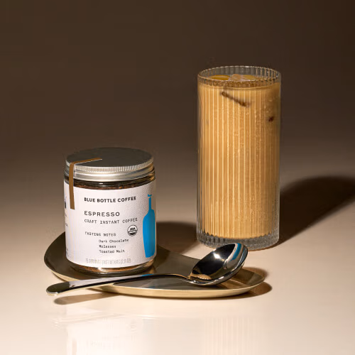 Image of coffee container and glass of coffee.
